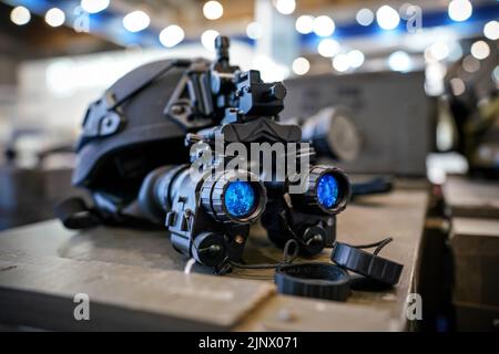 Occhiali per visione notturna su casco militare, primo piano rispetto alle lenti blu riflettenti Foto Stock