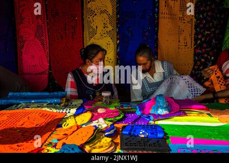 Le donne indigene messicane vendono bandiere di carta scalpellate per le celebrazioni del giorno dei morti sul mercato a Xochimilco, Città del Messico, Messico. Foto Stock