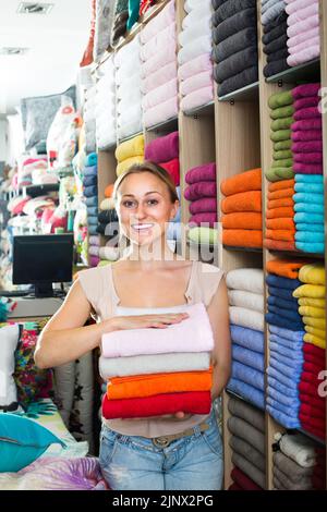 donna cliente che raccoglie asciugamani da bagno. Foto Stock