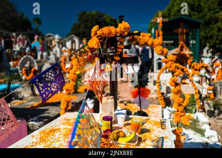 Tombe, decorate con fiori di marigold, sono viste durante la celebrazione del giorno dei morti nel cimitero di Tlapa de Comonfort, Messico. Foto Stock