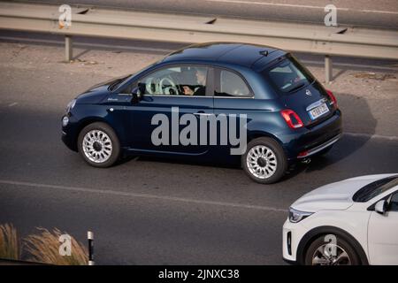 Conducente su una Fiat 500 con telefono cellulare durante la guida su autostrada spagnola Foto Stock