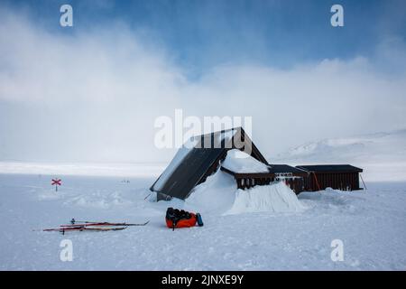 Il cielo e uno zaino vicino a una capanna di emergenza sul sentiero di Kungsleden tra Abisko e Nikkaluokta durante la stagione invernale, Lapponia, Svezia Foto Stock