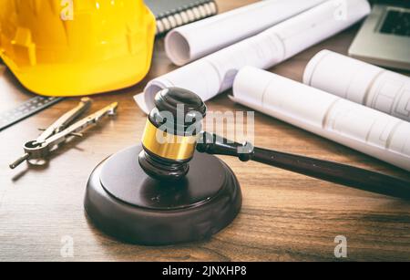 Costruzione e diritto del lavoro. Giudica i disegni di gavel e di costruzione su un tavolo di legno, vista ravvicinata. Foto Stock