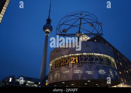 Berlino, Germania: L'Orologio mondiale di Urania e il Fernsehturm (Torre televisiva) ad Alexanderplatz, di notte Foto Stock