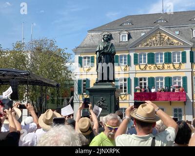 Bonn, Germania. 14 agosto 2022, Renania settentrionale-Vestfalia, Bonn: Gli spettatori fotografano e osservano il monumento di Beethoven restaurato e svelato di fronte all'ufficio postale principale. Una celebrazione storica del 175th° anniversario del monumento di Beethoven avrebbe dovuto svolgersi due anni fa. Tuttavia, a causa di Corona non poteva avvenire in quel momento. Una nuova occasione è stata offerta dal restauro completo del monumento, che è stato riportato sul suo piedistallo per quasi sei settimane dopo un trattamento di bellezza di sei mesi in un laboratorio. Credit: dpa Picture Alliance/Alamy Live News Foto Stock