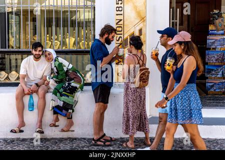 Un gruppo di giovani visitatori nella città di Thira, Santorini, Isole Greche, Grecia. Foto Stock