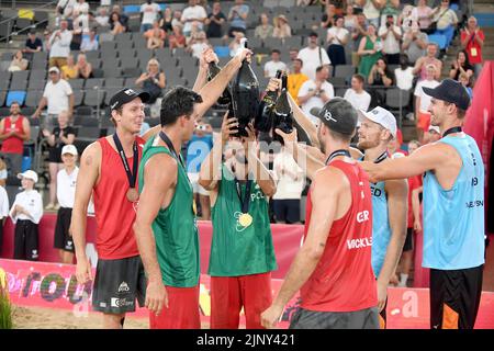 Amburgo, Germania. 14th ago, 2022. Beach Volleyball, Beach Pro Tour, 14 agosto 2022, Stadio di Amburgo Rothenbaum, i vincitori della medaglia brindano insieme a bottiglie di champagne. Credit: Michael Schwartz/dpa/Alamy Live News Foto Stock