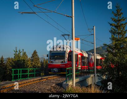 Treni alla stazione di Strba sotto le montagne Vysoke Tatry in estate mattina Foto Stock