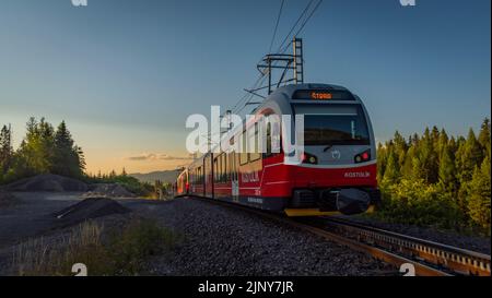 Treni alla stazione di Strba sotto le montagne Vysoke Tatry in estate mattina Foto Stock