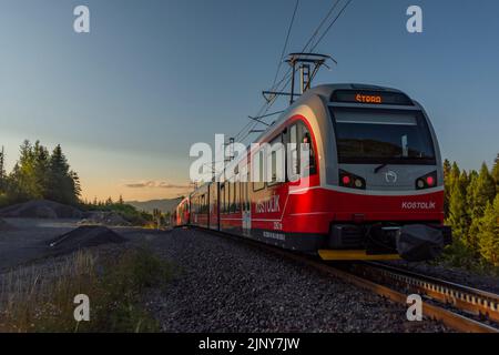 Treni alla stazione di Strba sotto le montagne Vysoke Tatry in estate mattina Foto Stock