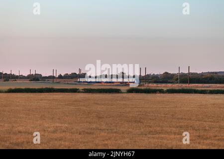 Operatore di accesso aperto Firstgroup Lumo classe 803 treno elettrico sulla linea principale della costa orientale a 4 binari nello Yorkshire passando per la campagna arabile Foto Stock