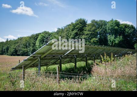 Una fila di pannelli solari installati in un campo rurale nel Regno Unito. Questa vista è presa dal retro dei pannelli Foto Stock