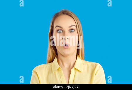 Studio headshot di giovane donna che guarda qualcosa con divertente sorpresa espressione del viso Foto Stock