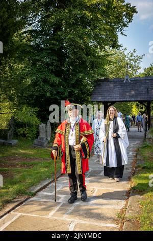 Lymm, Warrington, Cheshire, Inghilterra, Regno Unito. 14th ago, 2022. L'antica tradizione di Rushbearing è stata rivivuta con una processione dal centro del villaggio, riunirsi vicino alla diga inferiore circa 4 pm, e poi elaborare il Dingle dopo la città Crier Peter Powell. Il festival si è concluso con l'intrattenimento dei ballerini Morris prima di un servizio all'interno della chiesa di Santa Maria. Pietro li conduce attraverso la porta di Lico nella chiesa. Credit: John Hopkins/Alamy Live News Foto Stock