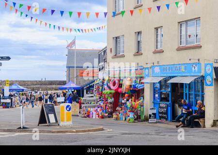 Mostra a bordo strada di gonfiabili colorati e giocattoli da spiaggia in un negozio del Cobb a Lyme Regis sulla Jurassic Coast a Dorset, nel sud dell'Inghilterra Foto Stock