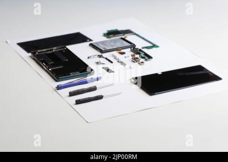 Defocus riparazione elettronica. Tecnico che ripara il circuito stampato elettronico con saldatore. Ingegnere smontaggio componenti smartphone e guasto Foto Stock