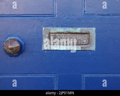 Antica cassetta con verdigris ossidato e LETTERE scritte allestite in vecchio sportello in legno verniciato blu accanto al manico in ottone Foto Stock
