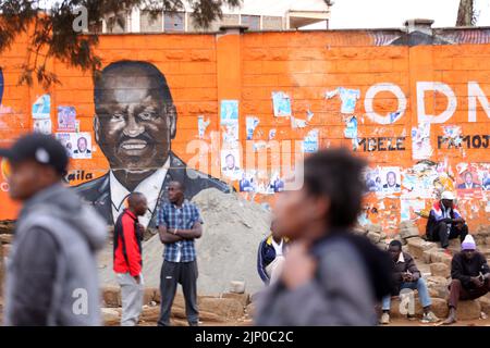 Nairobi, Kenya. 14th ago, 2022. La gente siede intorno al murale del frontone presidenziale Raila Odinga a Kibera. La vita quotidiana come il paese attende i risultati elettrici. Il Kenya ha vissuto in passato una violenza post-sondaggio. L'organo elettorale IEBC di Nairobi sta attualmente ottenendo risultati con un periodo di sette giorni per annunciare i risultati che scadono martedì 16th agosto 2022. Il corpo indicava un lento processo di tallying. (Foto di Billy Mutai/SOPA Images/Sipa USA) Credit: Sipa USA/Alamy Live News Foto Stock