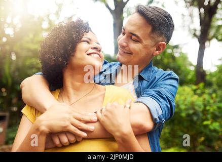 Vi amo tanto, una giovane coppia affettuosa che condivide un momento intimo nel parco. Foto Stock