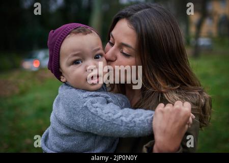 Mommy appena cant ottenere abbastanza delle mie guance carine. Una madre che si lega con il suo figlio piccolo all'aperto. Foto Stock