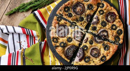 Piastra con gustosa focaccia italiana sul tavolo Foto Stock