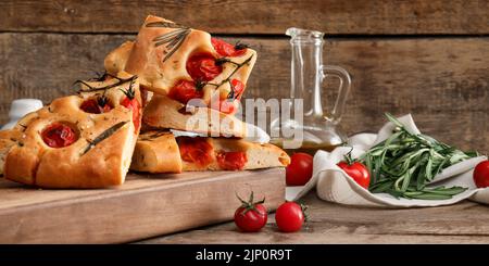 Tradizionale focaccia italiana con pomodori su sfondo ligneo Foto Stock