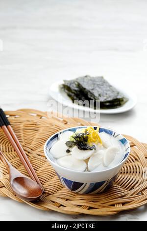 Tteokguk o zuppa di torta di riso a fette, piatto tradizionale coreano mangiato durante la celebrazione del Seollal di Capodanno coreano. Copia spazio per testo Foto Stock