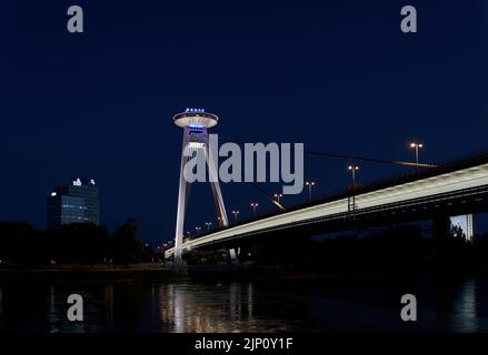 Il ponte della rivolta Nazionale Slovacca a Bratislava SNP sul Danubio in serata con un ristorante ad una grande altezza Foto Stock
