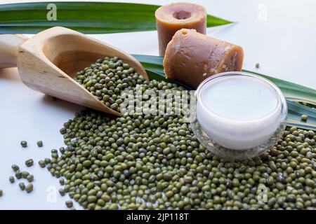 Vista dall'alto del porridge di fagioli mung o del bubur kacang hijau indonesiano con latte di cocco, foglie di panda e cucchiaio di legno Foto Stock