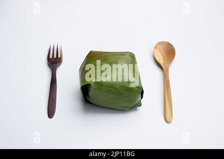 Nasi timbel indonesiano o riso bianco al vapore avvolto in foglia di banana Foto Stock