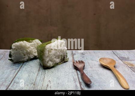 Nasi timbel indonesiano o riso bianco al vapore avvolto in foglia di banana Foto Stock