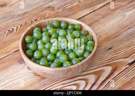 Frutti di bosco maturi in ciotola su tavola di legno. Raccolta delle bacche. Foto Stock