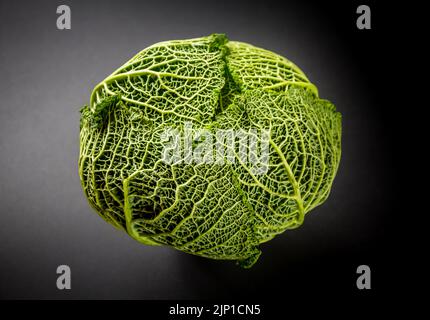 Cavolo savoy fresco isolato su uno sfondo nero Foto Stock
