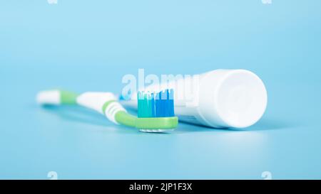 dentifricio e uno spazzolino da denti su sfondo medico blu, cura dentale. Foto Stock