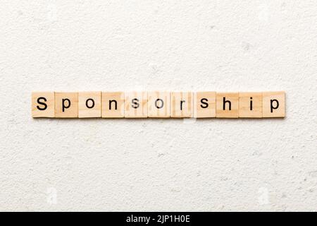 Sponsorizzazione parola scritta sul blocco di legno. La sponsorizzazione del testo in tabella, concetto. Foto Stock