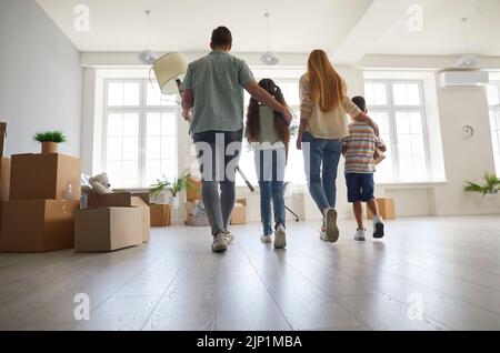 La famiglia giovane con due bambini si sposta in un nuovo posto per vivere e ispeziona la nuova casa. Foto Stock