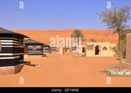 Campeggio in stile beduino accanto ad una enorme duna di sabbia nel deserto di Wahiba Sands in Oman. Foto Stock