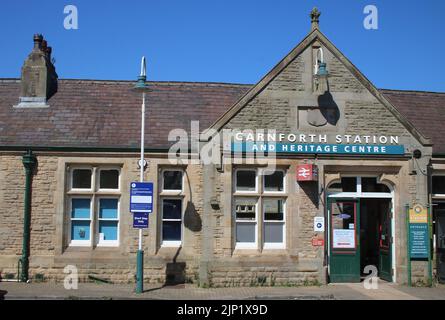 La stazione di Carnforth e l'entrata principale dell'Heritage Centre, l'esterno dell'edificio con le relative indicazioni e il logo della doppia freccia della British Rail, agosto 2022. Foto Stock