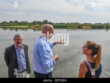 15 agosto 2022, Brandeburgo, Lebus: Axel Vogel (l., Bündnis 90/Die Grünen), Ministro dell'ambiente del Brandeburgo, Dietmar Woidke (SPD), Ministro Presidente del Brandeburgo, e Katja Klemke, Vice Direttore dell'Ufficio, si trovano in occasione di un evento stampa sul disastro ambientale sul fiume Oder, al confine tedesco-polacco. Per diversi giorni, la massiccia uccisione di pesci nel fiume Oder ha preoccupato le autorità e i residenti del fiume in Germania e Polonia. Secondo l'Agenzia polacca per la protezione dell'ambiente, l'uccisione di pesci nel fiume Oder è stata probabilmente provocata dall'inquinamento idrico causato dall'industria Foto Stock