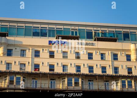 La gente guarda fuori dal balcone di Park Inn Palace, Palace Hotel, Pier Hill, Marine Parade, Southend on Sea, Essex. Hotel fronte mare a tarda sera incandescente Foto Stock