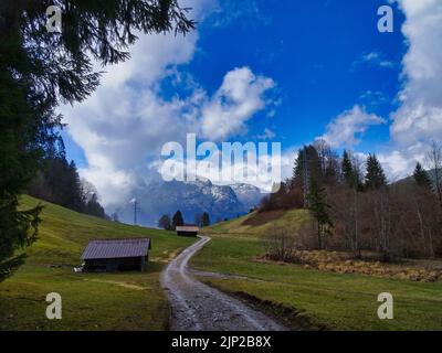 Una bella vista di un piccolo villaggio con alta catena montuosa innevata sullo sfondo Foto Stock