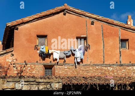 Vecchia casa con vestiti lavati appesi su corde appese alle finestre. Albarracin Spagna. Foto Stock