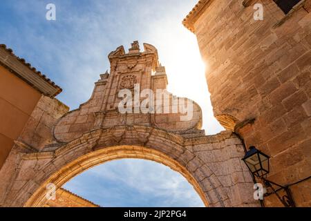 Arco di vecchio edificio in pietra con sole riflesso sul cielo blu. La Mancha Spagna. Europa. Foto Stock