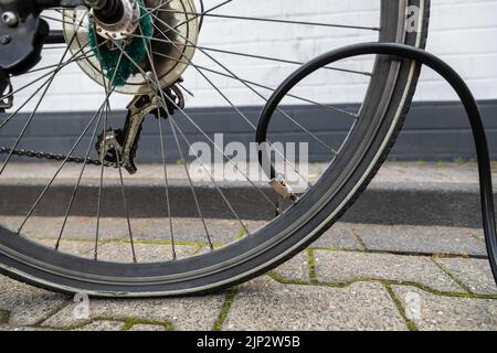 Un primo piano di gonfiaggio pneumatico piatto di bicicletta con tubo con attraverso valvola auto Foto Stock