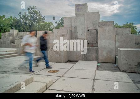 due persone che camminano, lunga esposizione sfocata, in pietra di sfondo scultura diversi livelli Foto Stock