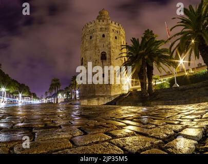 Torre del Oro a Siviglia, scena notturna con foto a lunga esposizione e basso punto di vista accanto al terreno acciottolato. Spagna. Foto Stock