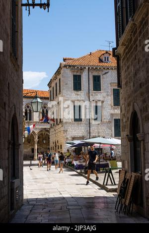 Un colpo verticale di persone che camminano per il mercato di Dubrovnik durante il giorno di sole estate, Croazia Foto Stock