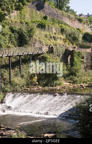 Onda di calore nel Regno Unito. Due giovani donne che si raffreddano nel fiume Goyt a New Mills, Derbyshire, Inghilterra. Foto Stock