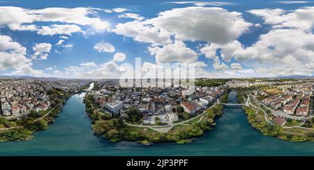 Una vista panoramica di una città con un cielo nuvoloso blu Foto Stock