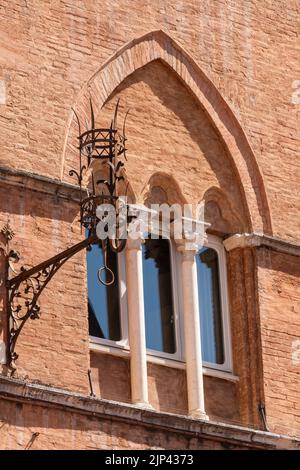 Lanterna e finestra sulla facciata di un'antica casa a Siena Foto Stock